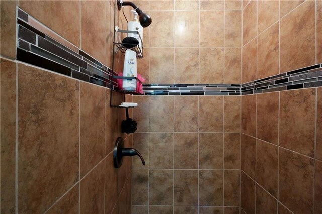 interior details featuring tiled shower