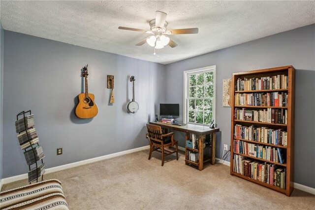 carpeted office featuring baseboards, ceiling fan, and a textured ceiling