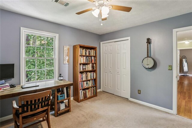 home office featuring baseboards, a ceiling fan, carpet floors, and visible vents