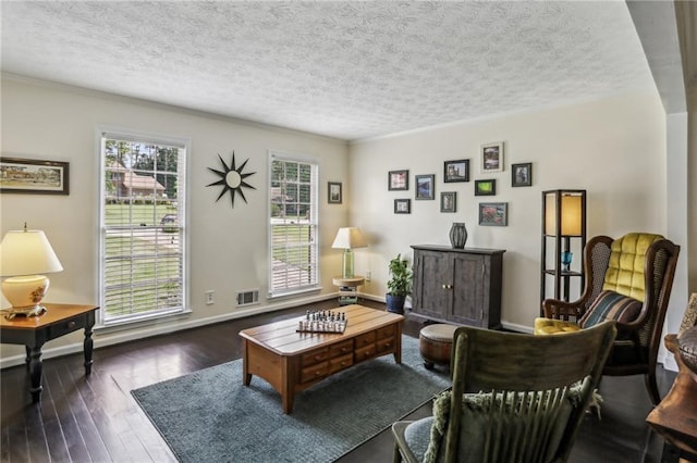 living area featuring a textured ceiling, hardwood / wood-style floors, and visible vents