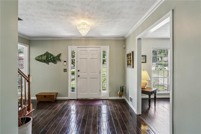 entrance foyer with an inviting chandelier, wood-type flooring, a textured ceiling, baseboards, and visible vents