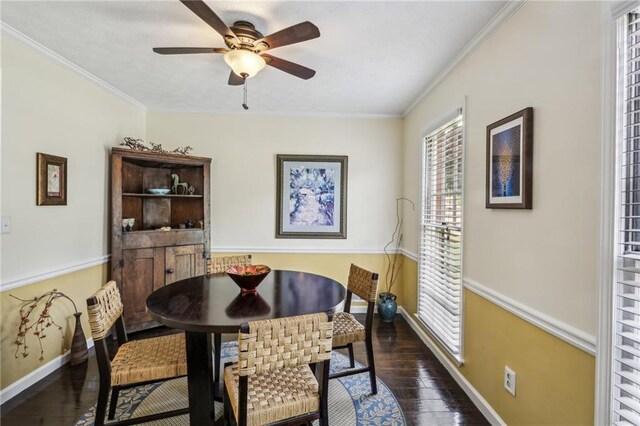dining space featuring crown molding, dark wood-style flooring, baseboards, and a ceiling fan