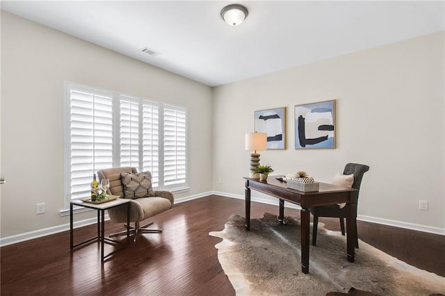 home office featuring wood finished floors, visible vents, and baseboards