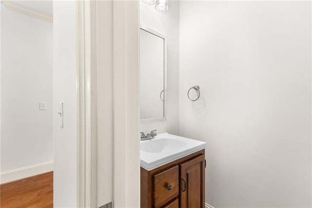 bathroom with wood finished floors, vanity, and baseboards