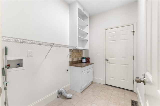 clothes washing area featuring hookup for a washing machine, cabinet space, hookup for an electric dryer, light tile patterned flooring, and baseboards