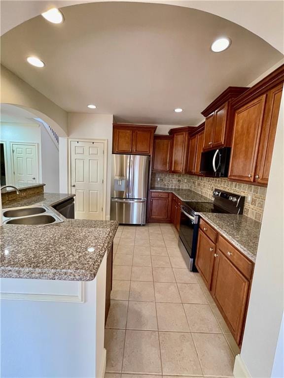 kitchen with light tile patterned flooring, range with electric cooktop, a sink, stainless steel fridge with ice dispenser, and decorative backsplash