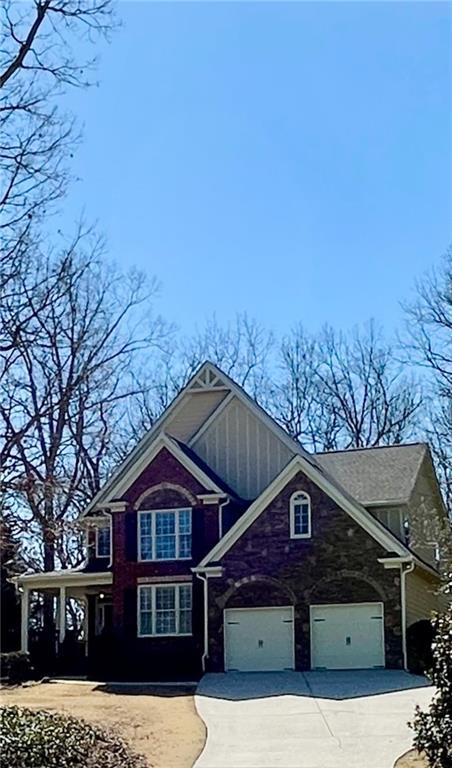 craftsman-style home with stone siding and concrete driveway