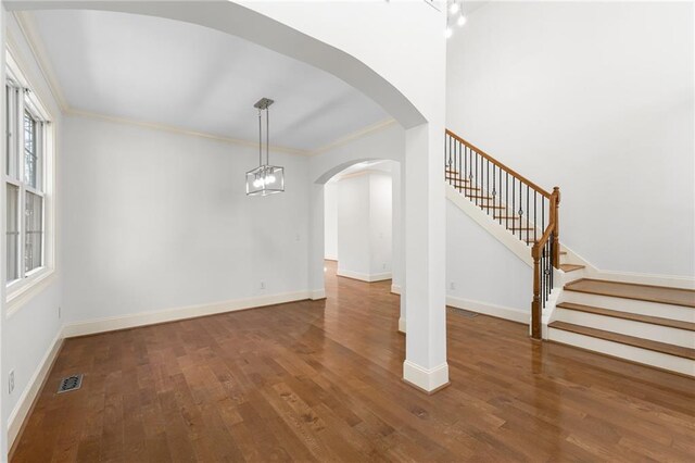 interior space with visible vents, baseboards, stairway, wood finished floors, and crown molding