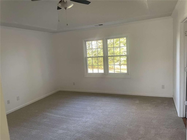 spare room featuring crown molding, ceiling fan, and dark colored carpet