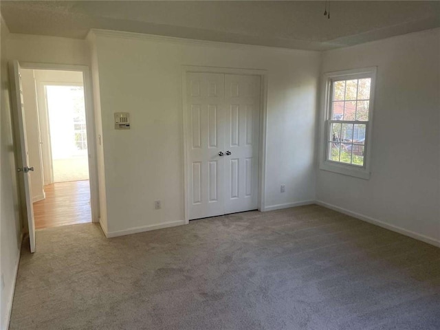 unfurnished bedroom featuring a closet and light carpet