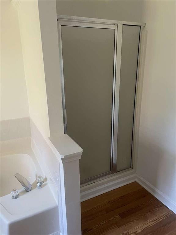 bathroom featuring wood-type flooring and independent shower and bath