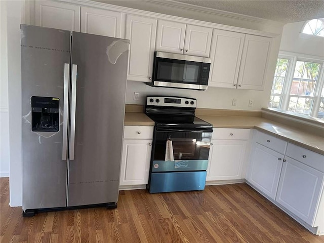 kitchen with stainless steel appliances, dark hardwood / wood-style flooring, and white cabinets