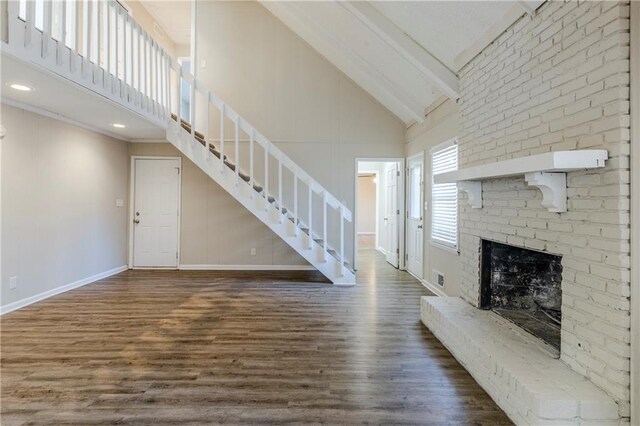3225 Redona Dr, Atlanta, GA 30349 - unfurnished living room with a brick fireplace, high vaulted ceiling, and dark hardwood / wood-style flooring