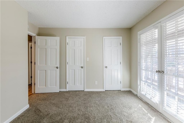 3225 Redona Dr, Atlanta, GA 30349 - unfurnished bedroom featuring access to exterior, french doors, carpet floors, and a textured ceiling