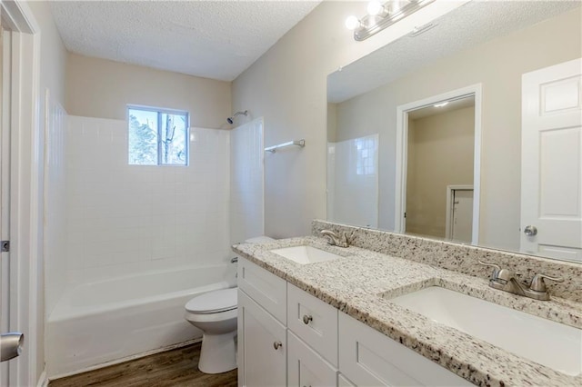 3225 Redona Dr, Atlanta, GA 30349 - full bathroom with toilet, tiled shower / bath, a textured ceiling, vanity, and hardwood / wood-style floors