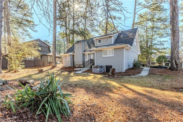 3225 Redona Dr, Atlanta, GA 30349 - rear view of house featuring a lawn and central AC