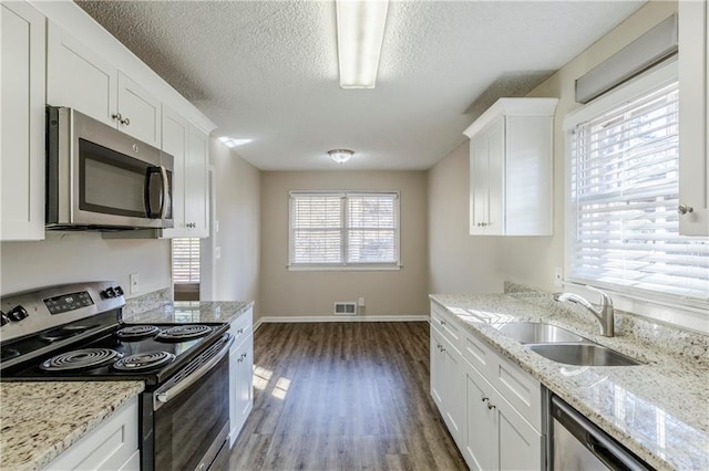3225 Redona Dr, Atlanta, GA 30349 - kitchen with white cabinetry, appliances with stainless steel finishes, sink, and light stone counters