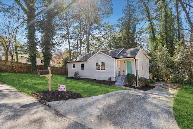 view of front of home with crawl space, fence, and a front yard