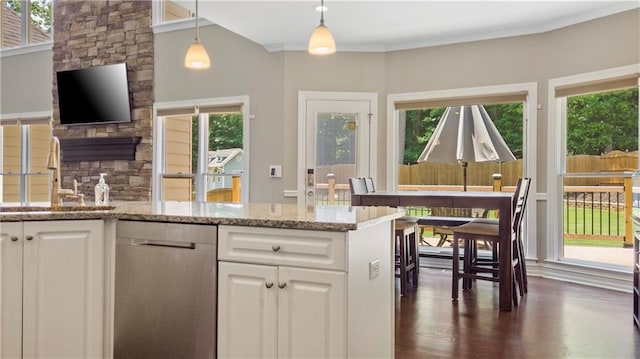kitchen featuring pendant lighting, white cabinetry, light stone counters, a sink, and dishwasher