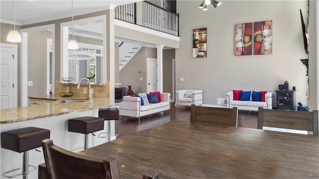 living room with stairs, visible vents, ornamental molding, and dark wood-type flooring
