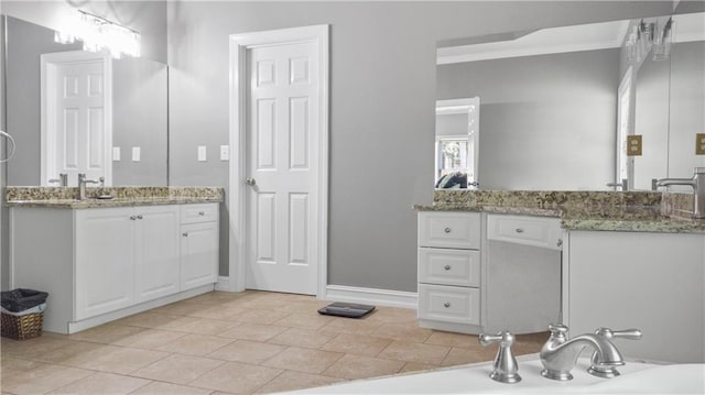 full bathroom with crown molding, baseboards, and two vanities