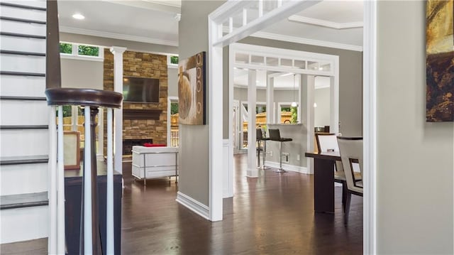 interior space with crown molding, baseboards, wood finished floors, and a fireplace