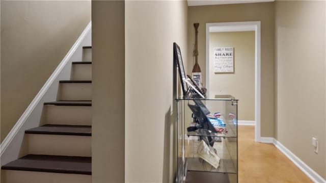 staircase with baseboards and concrete floors