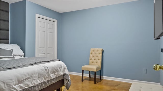 bedroom featuring baseboards, a closet, and wood finished floors