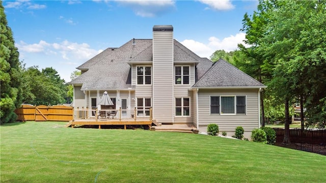 back of house with a lawn, fence, a wooden deck, and a chimney