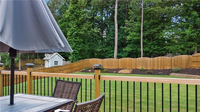 wooden terrace with a lawn, a fenced backyard, and outdoor dining space