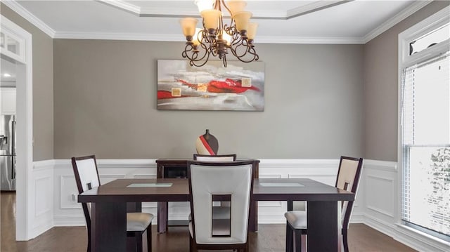 dining room featuring an inviting chandelier, plenty of natural light, ornamental molding, and a decorative wall