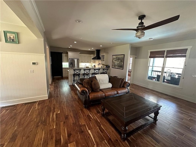 living room featuring dark wood-type flooring and ceiling fan