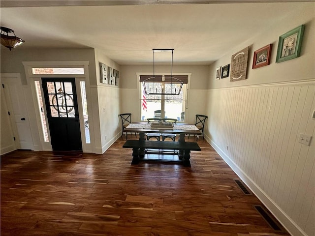 dining area featuring dark wood-type flooring and a notable chandelier