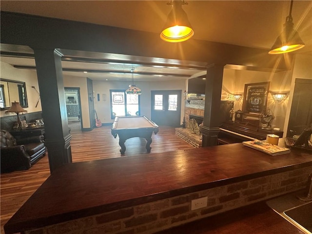 rec room with a stone fireplace, pool table, and dark hardwood / wood-style flooring