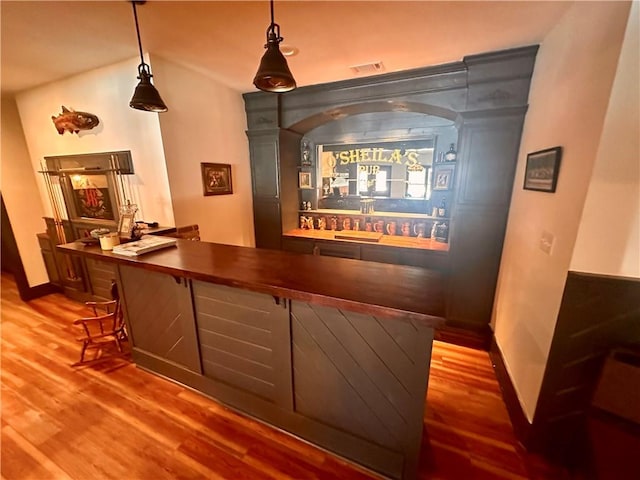 interior space featuring hardwood / wood-style floors, butcher block countertops, and hanging light fixtures