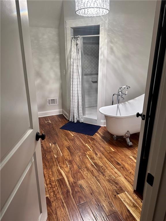 bathroom with independent shower and bath, hardwood / wood-style floors, and a notable chandelier