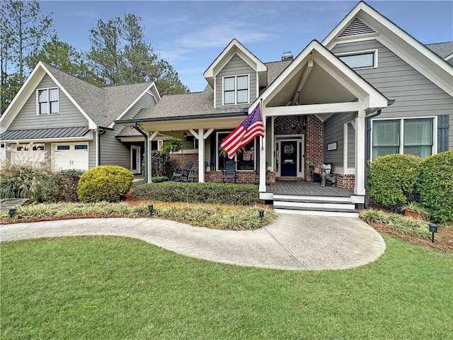 view of front of house featuring a front yard, a garage, and a porch