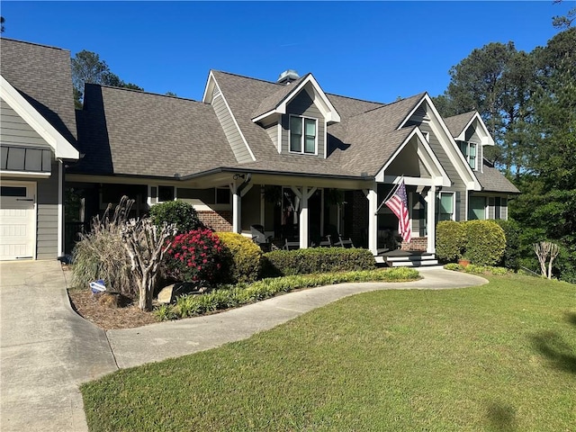 view of front facade with a garage, a front lawn, and a porch