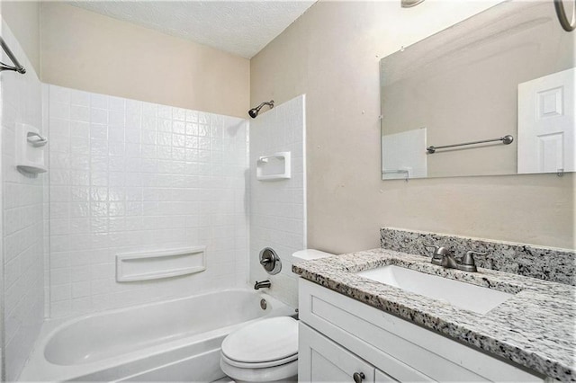 full bathroom with vanity, a textured ceiling, toilet, and tiled shower / bath