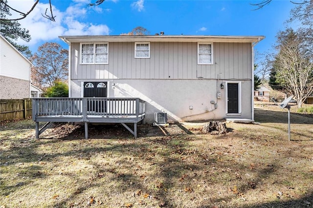 back of house featuring cooling unit, a lawn, and a wooden deck