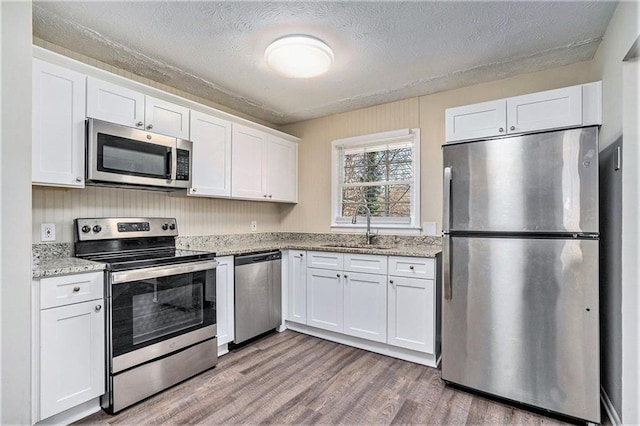 kitchen with white cabinets, stainless steel appliances, and sink