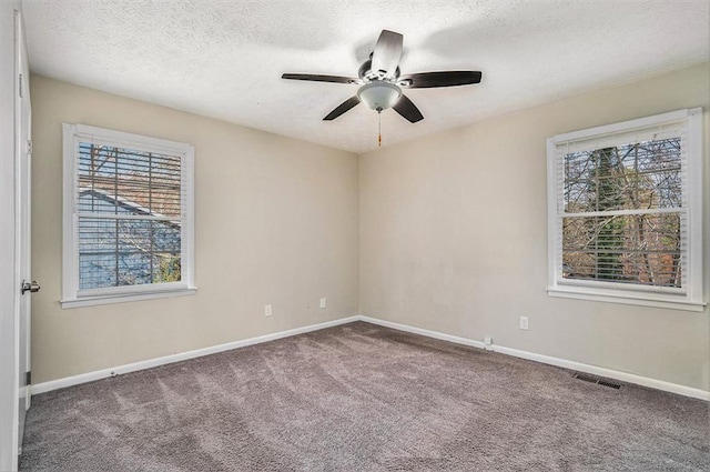 spare room with ceiling fan, carpet, and a textured ceiling