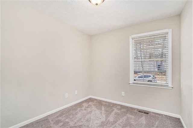 unfurnished room featuring carpet floors and a textured ceiling