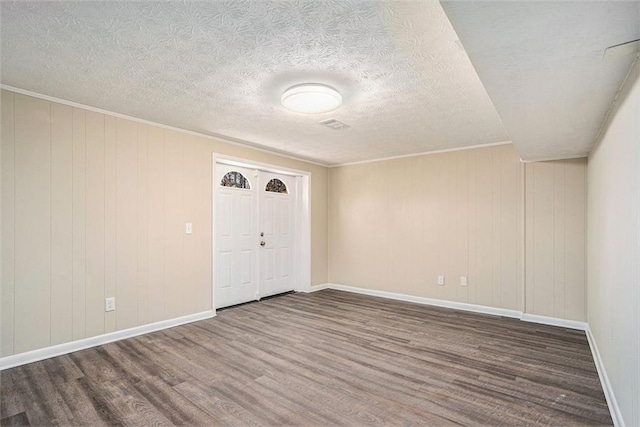 entryway featuring dark hardwood / wood-style floors, crown molding, and a textured ceiling