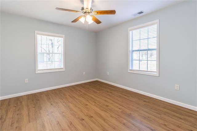 empty room with light hardwood / wood-style floors, ceiling fan, and a healthy amount of sunlight