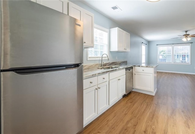 kitchen featuring kitchen peninsula, appliances with stainless steel finishes, white cabinetry, and sink