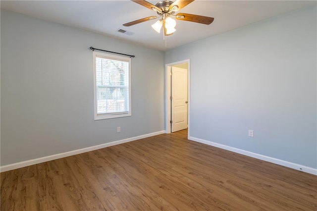 empty room with ceiling fan and hardwood / wood-style flooring