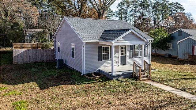 bungalow-style home with a front lawn and cooling unit