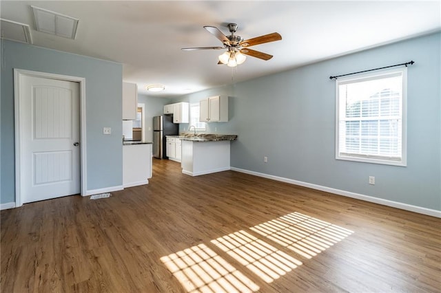 unfurnished living room with hardwood / wood-style floors, ceiling fan, and sink