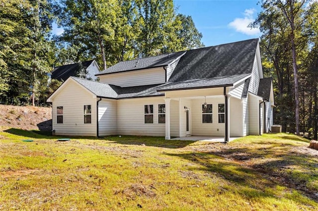 back of property featuring a lawn and a patio